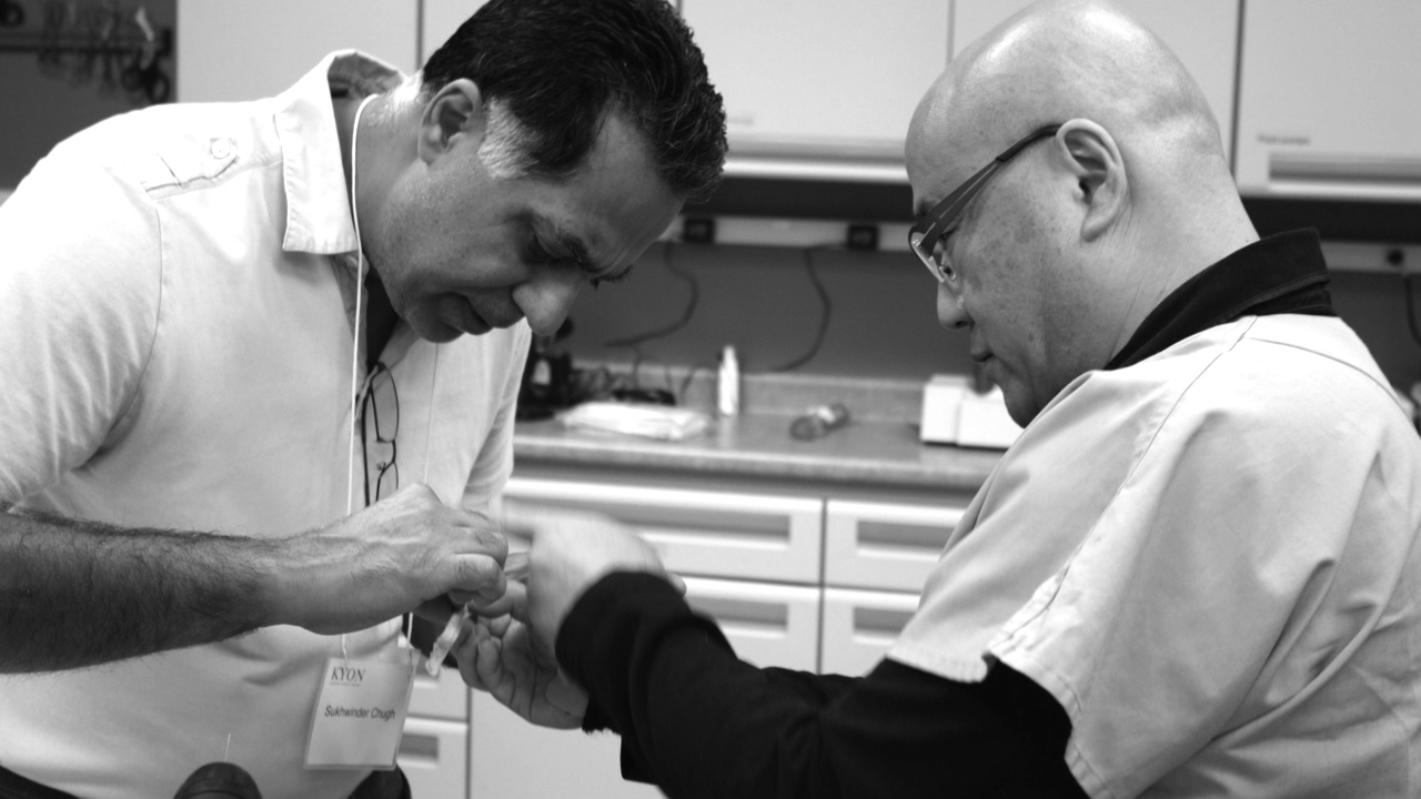 Dos hombres trabajando en estrecha colaboración en un curso de reparación de fracturas veterinarias